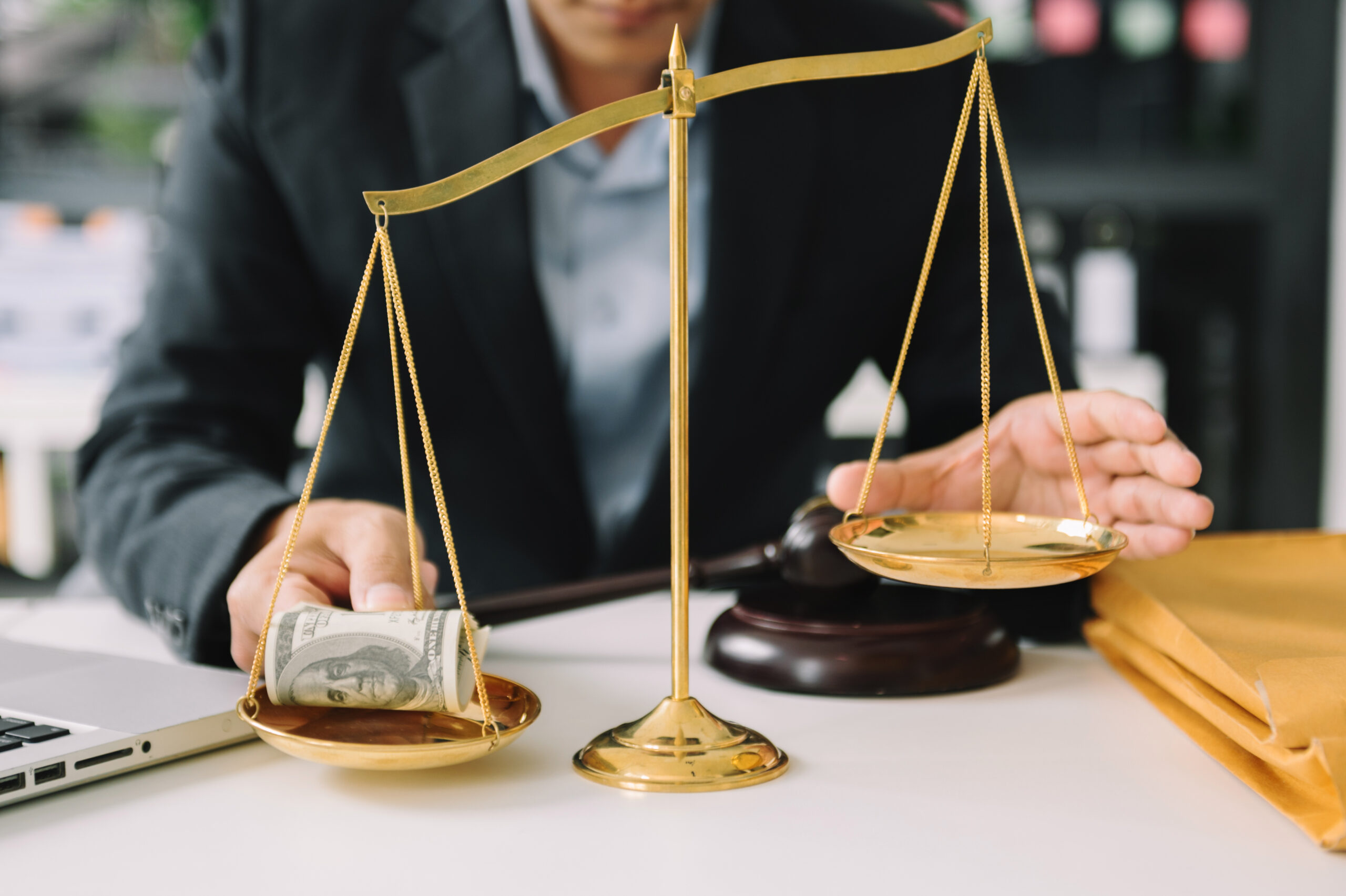 Male lawyer in the office with brass scale on wooden table. just